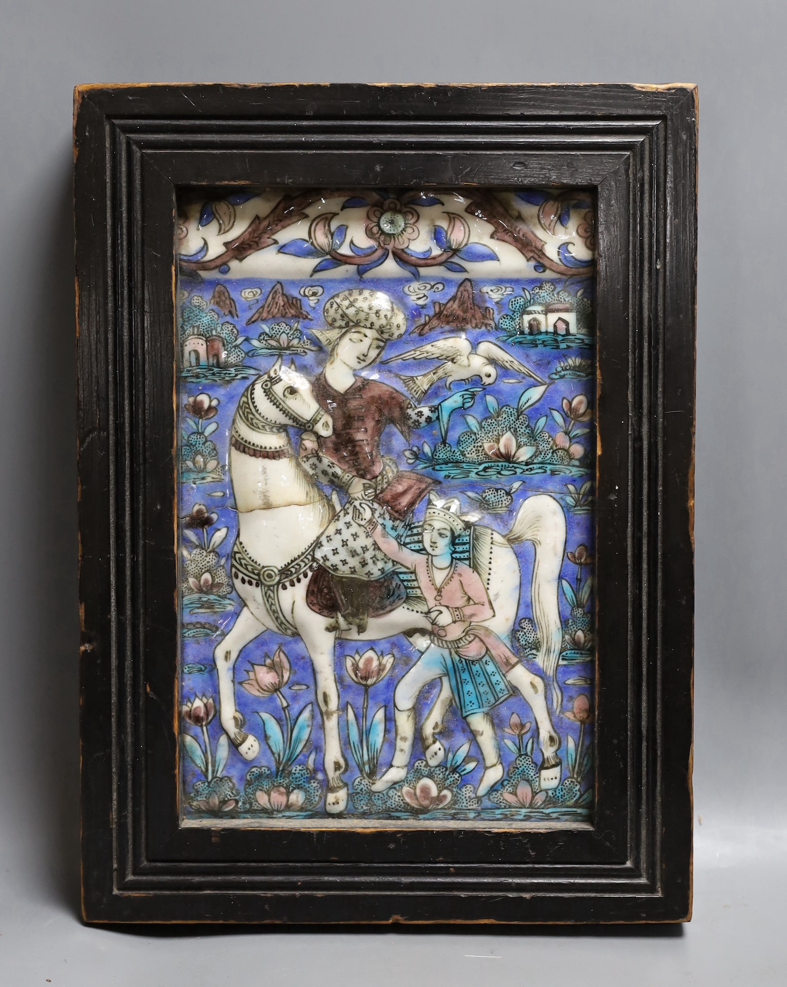 A framed 19th century Persian polychrome tile, Qajar dynasty, 25x16cm